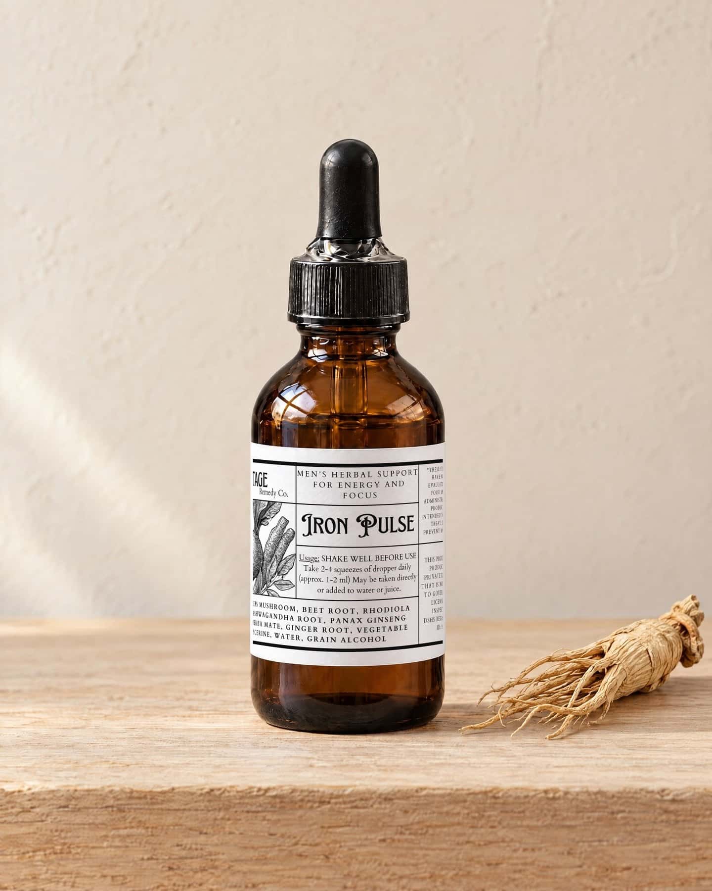 A dropper bottle of IronPulse - Men's Energy Elixir on a pale oak shelf, a dried ginseng root beside it