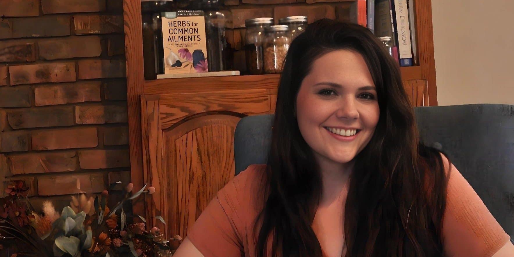 Morgan Murphy at home, in front of a bookshelf of herbal references and jars